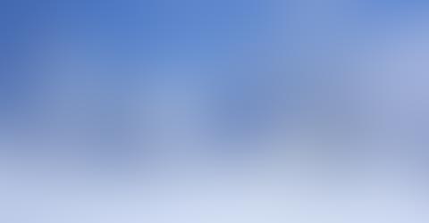 Blurry gradient background with blue and white tones.