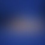 Blurred image with indistinct shapes on a blue background.