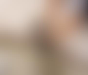 A blurred image with neutral tones and indistinct shapes.