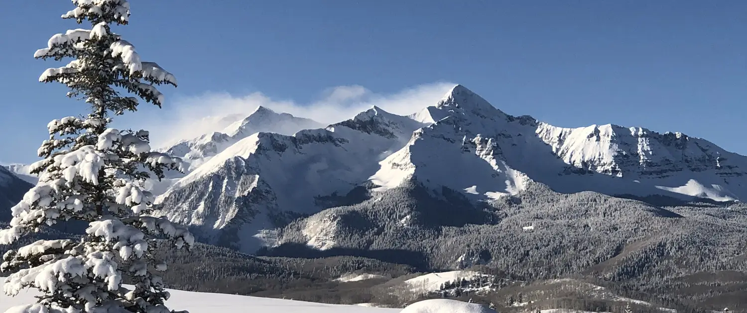 Snow-covered mountain peaks under a clear blue sky.
